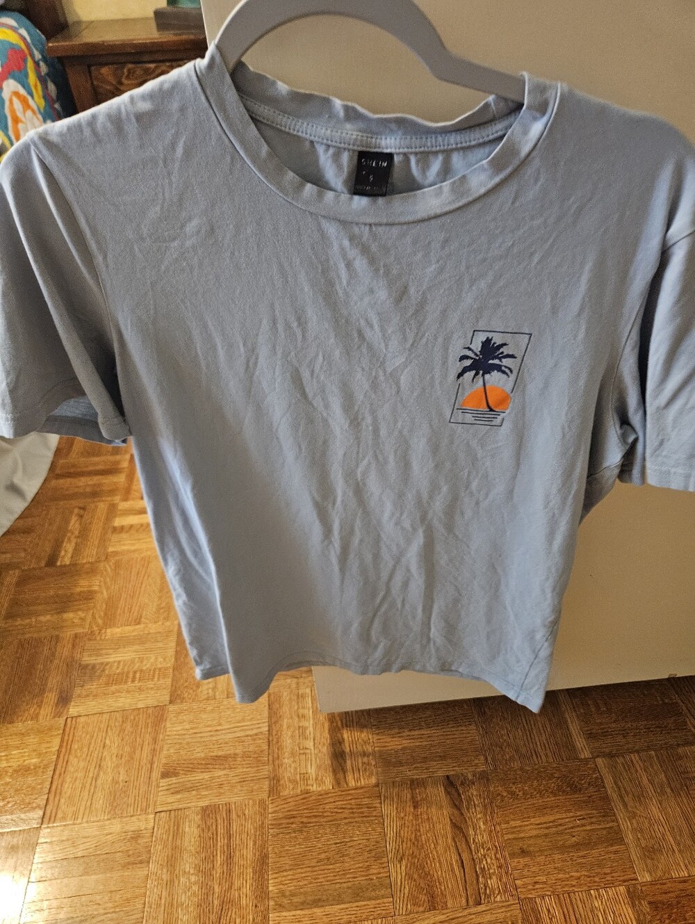 SHEIN light gray tee with black label and orange palm graphic